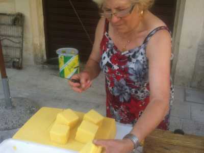 Maria la pantofolaia mentre taglia la polenta per fare la forma delle sgagliozze